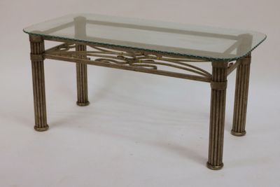 une table en verre avec des pieds en métal et un plateau en verre