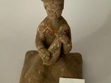 figurine représentant un homme assis sur un rocher sur lequel figure le chiffre 24