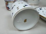 three cups and a bowl sitting on a table