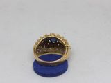 a close up of a gold ring with a blue stone in it