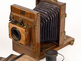 an old wooden camera with a leather case on it