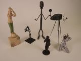Plusieurs figurines de types et de tailles variés sont exposées sur une surface blanche