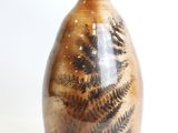 a brown vase with black and white designs on it