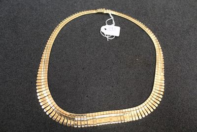 gold plated necklace on a black background with a white tag