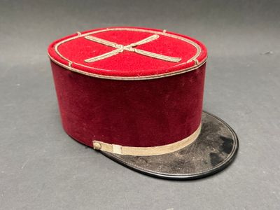 un haut-de-forme rouge orné d'un ruban doré
