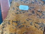 two old books sitting on top of each other on a blue surface