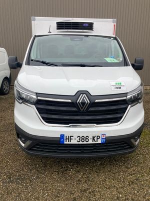 l'avant d'une camionnette blanche garée devant un immeuble