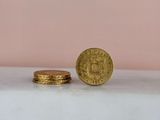 two gold coins sitting on top of a marble counter top