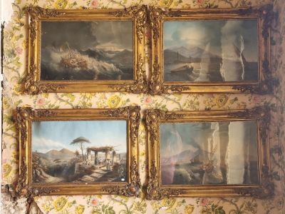 four paintings hanging on the wall of a room