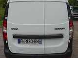 a white van parked in a parking lot with trees in the background