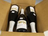trois bouteilles de vin dans un carton sur une table