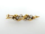 a close up of a gold and pearl hair clip on a white background