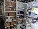 un garage où s'entassent des cartons et encore des cartons sur les étagères