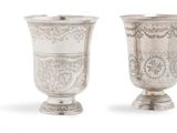 deux vases en argent ornés de motifs sur un fond blanc