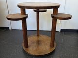 une petite table sur laquelle sont posés trois tabourets