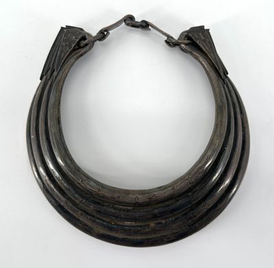 une image montrant un gros plan d'un bracelet en métal posé sur une surface blanche