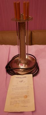 une table recouverte d'une nappe rose, sur laquelle se trouve un bougeoir en argent