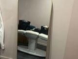 a large mirror in the corner of a bathroom