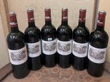 six bottles of red wine are lined up in a row