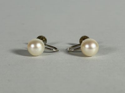 a pair of pearl earrings on a white surface