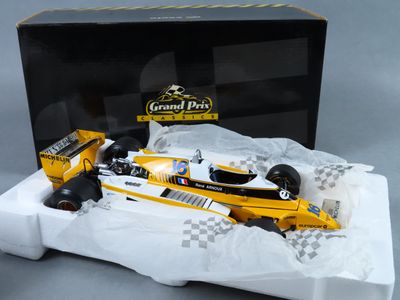 une maquette de voiture de course jaune devant une boîte noire