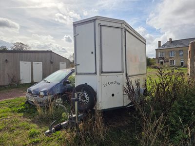une petite remorque garée dans l'herbe