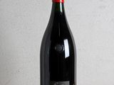 la bouteille de vin rouge est posée sur une table en bois