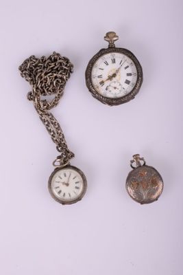 trois montres de poche anciennes et une chaîne posées sur un fond blanc