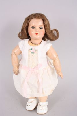 une poupée qui porte une robe blanche et des chaussures blanches