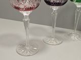 three wine glasses are lined up on a white table