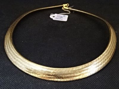 gros plan d'un collier en or sur une surface noire