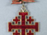 an image of a red and gold cross on a black ribbon