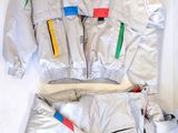 une image représentant une veste et un pantalon argentés ornés de rayures multicolores