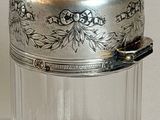 a small glass jar with a silver lid on a table
