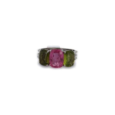 un gros plan d'une bague rose et verte sur fond blanc