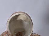 a small vase that is sitting on a table next to a cup