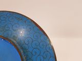 a blue plate with a gold rim on a white table