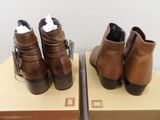 two pairs of brown leather boots with buckles on the sides of them