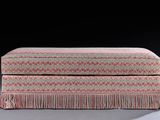 an upholstered ottoman with fringes and fringe trim