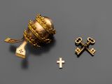 un gros plan d'un objet doré orné d'une croix