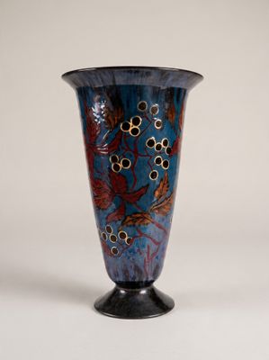 un vase bleu orné d'un motif, posé sur une table