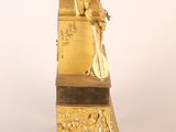 a gold statue of a man sitting on top of a chair