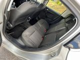 the back seats of a silver car with a black seat belt