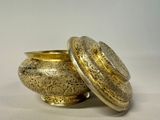 an image of a gold bowl with a lid on a white surface