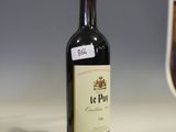 a bottle of wine sitting on a counter next to a glass of wine
