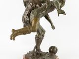 statue of a man and a woman playing with a soccer ball