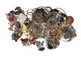 a pile of assorted jewelry on a white surface