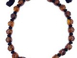 un collier composé de perles marron et noires, orné d'un pompon