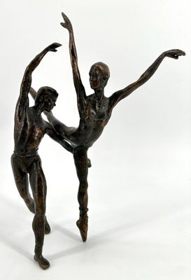 bronze statue of a couple of dancers on a white background