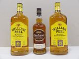 three bottles of whiskey sitting on top of a white table